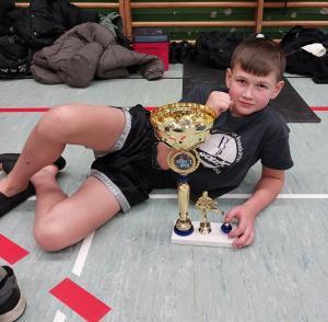 BB CHAMPIONS - Ehrung 009 - Schüler liegt mit Pokal und freut sich
